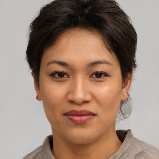 Joyful asian young-adult female with short  brown hair and brown eyes