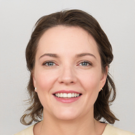 Joyful white young-adult female with medium  brown hair and grey eyes