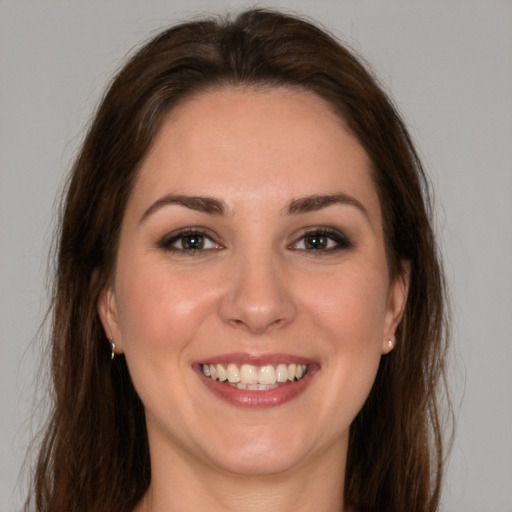 Joyful white young-adult female with long  brown hair and brown eyes