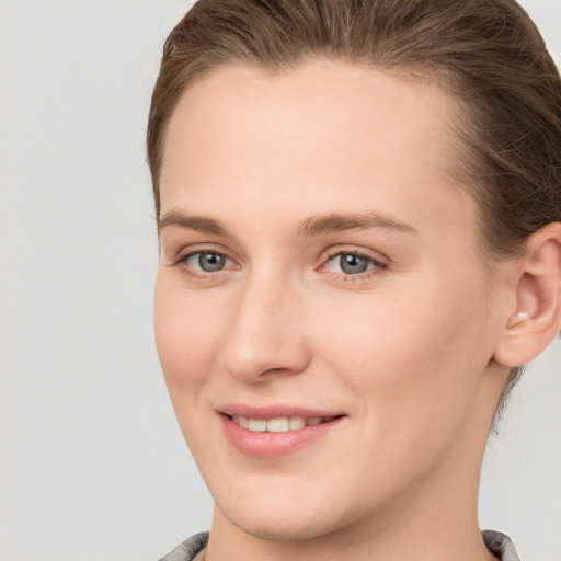 Joyful white young-adult female with medium  brown hair and grey eyes