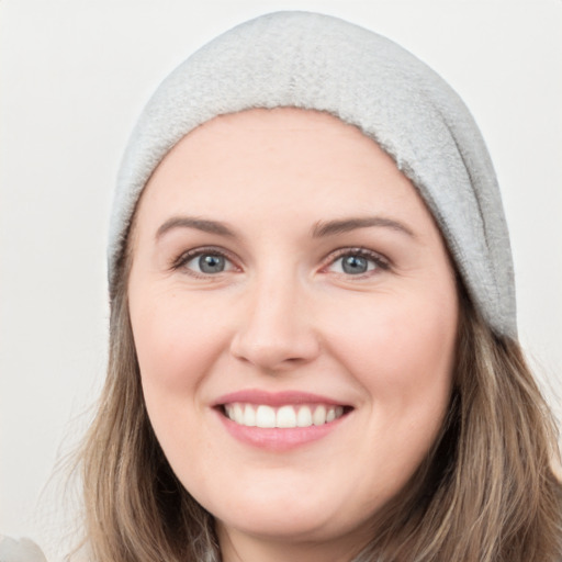 Joyful white young-adult female with long  brown hair and blue eyes