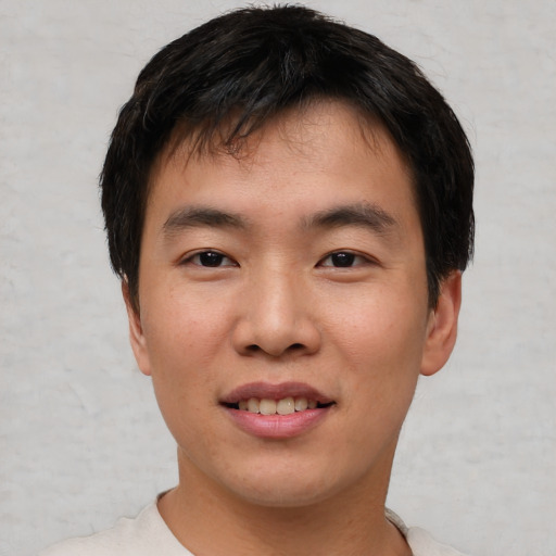 Joyful asian young-adult male with short  black hair and brown eyes