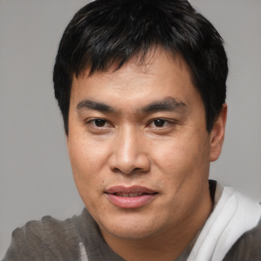 Joyful asian adult male with short  brown hair and brown eyes