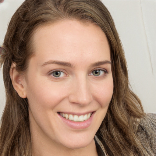 Joyful white young-adult female with long  brown hair and blue eyes