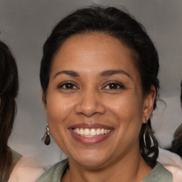 Joyful latino adult female with medium  brown hair and brown eyes