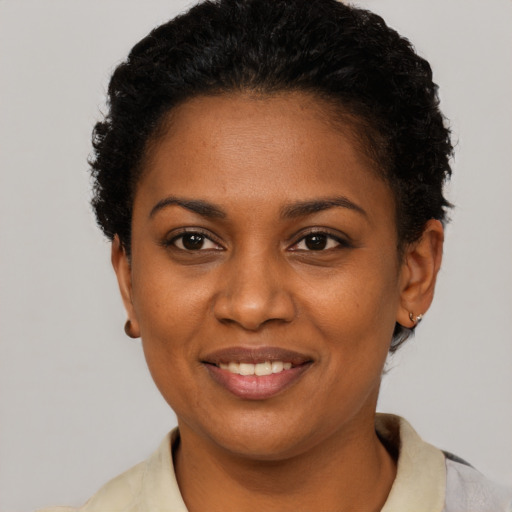 Joyful black young-adult female with short  brown hair and brown eyes