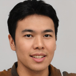 Joyful asian young-adult male with short  brown hair and brown eyes