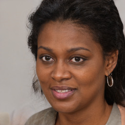 Joyful black young-adult female with long  brown hair and brown eyes