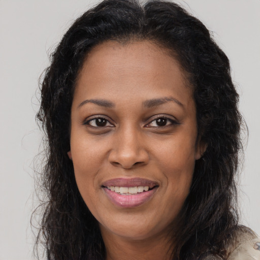 Joyful black young-adult female with long  brown hair and brown eyes