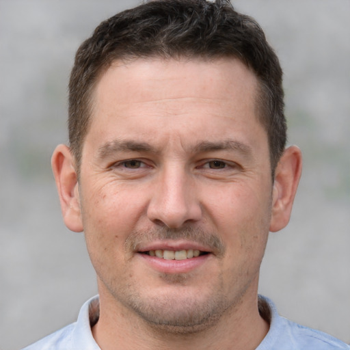 Joyful white adult male with short  brown hair and brown eyes