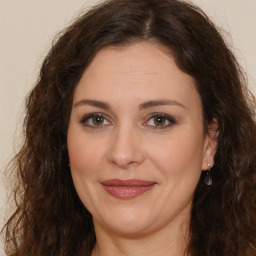 Joyful white adult female with long  brown hair and brown eyes