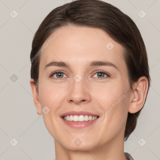 Joyful white young-adult female with medium  brown hair and grey eyes