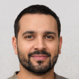 Joyful white young-adult male with short  black hair and brown eyes