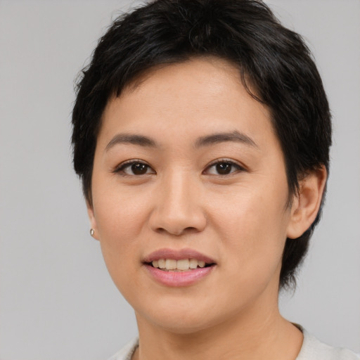 Joyful asian young-adult female with medium  black hair and brown eyes