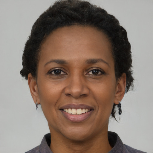 Joyful black adult female with short  brown hair and brown eyes