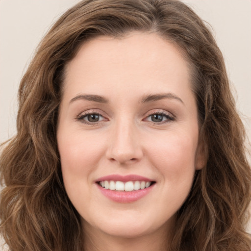 Joyful white young-adult female with long  brown hair and green eyes