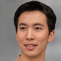 Joyful asian young-adult male with short  brown hair and brown eyes