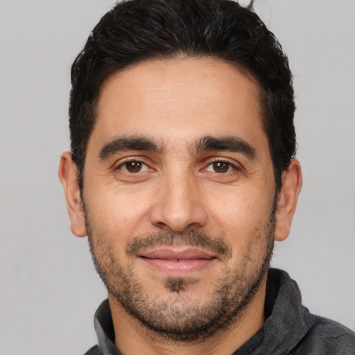 Joyful white young-adult male with short  black hair and brown eyes