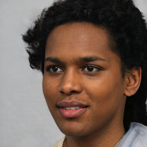 Joyful black young-adult female with short  black hair and brown eyes
