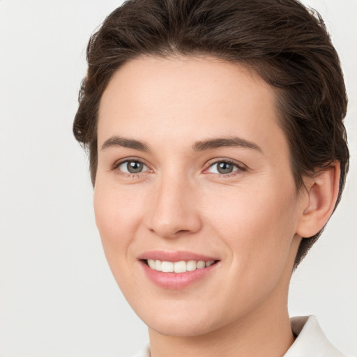 Joyful white young-adult female with short  brown hair and grey eyes