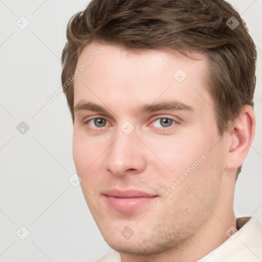 Joyful white young-adult male with short  brown hair and grey eyes