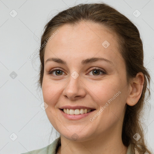 Joyful white young-adult female with long  brown hair and brown eyes