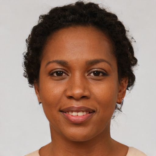Joyful black young-adult female with short  brown hair and brown eyes