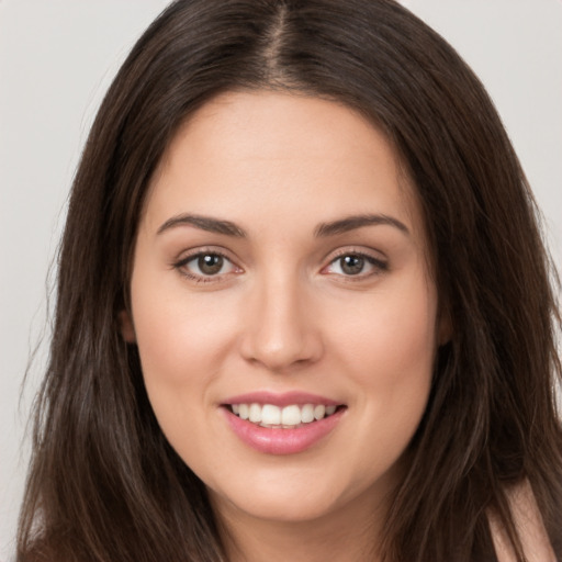 Joyful white young-adult female with long  brown hair and brown eyes