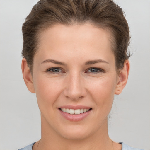 Joyful white young-adult female with short  brown hair and grey eyes