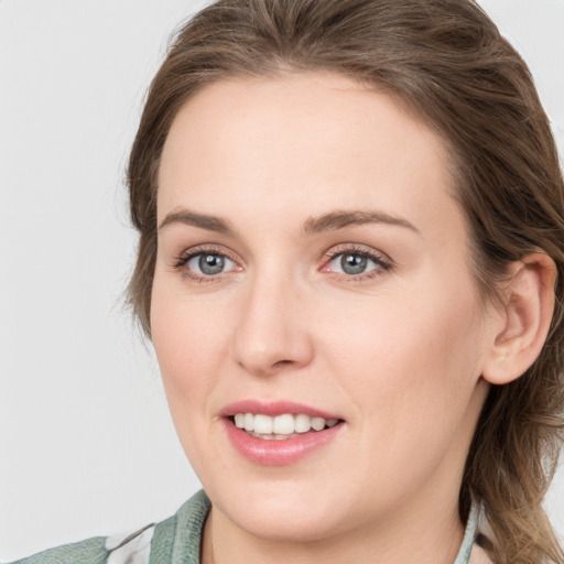 Joyful white young-adult female with medium  brown hair and blue eyes