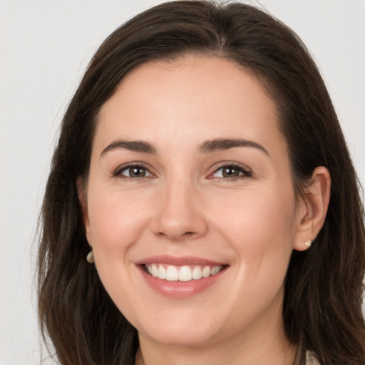 Joyful white young-adult female with long  brown hair and brown eyes