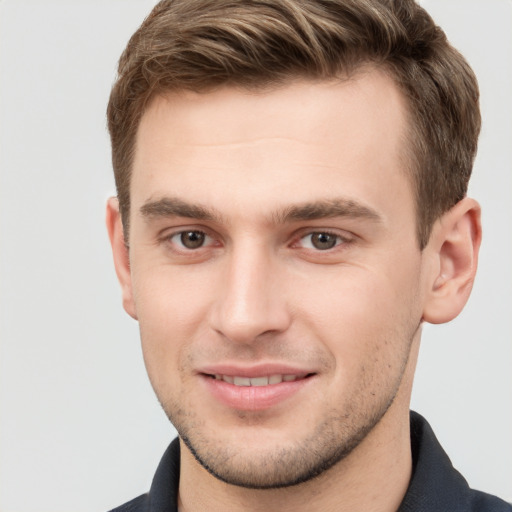 Joyful white young-adult male with short  brown hair and grey eyes