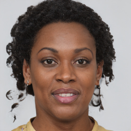 Joyful black adult female with short  brown hair and brown eyes