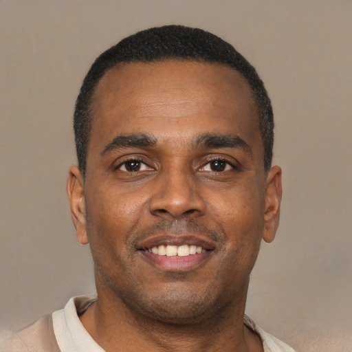 Joyful latino young-adult male with short  brown hair and brown eyes