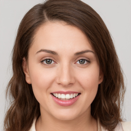 Joyful white young-adult female with medium  brown hair and green eyes