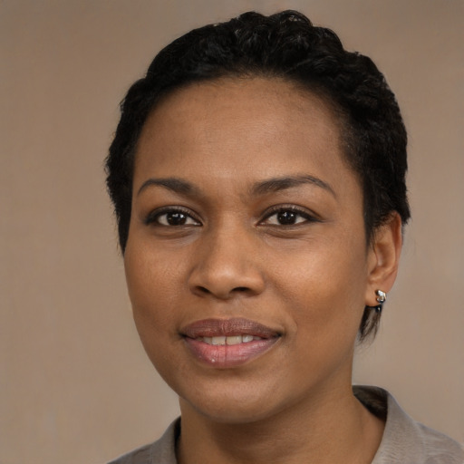 Joyful black young-adult female with short  black hair and brown eyes