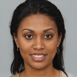 Joyful latino young-adult female with medium  brown hair and brown eyes