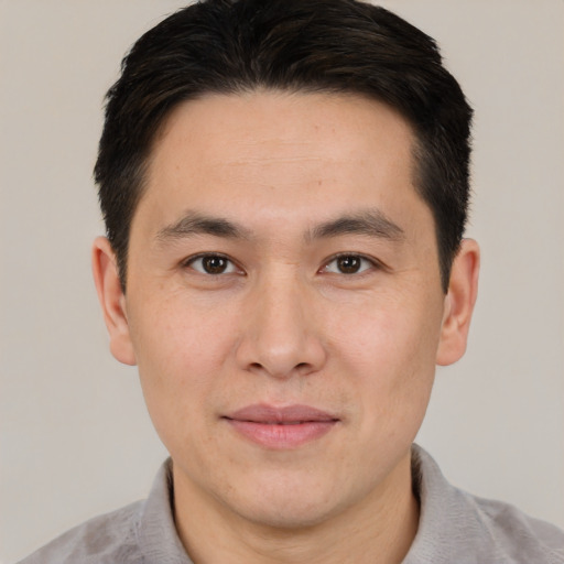 Joyful asian adult male with short  brown hair and brown eyes