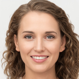 Joyful white young-adult female with long  brown hair and green eyes