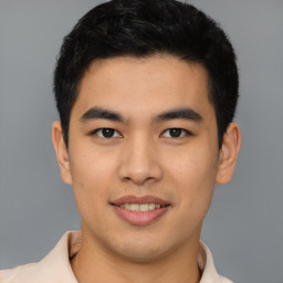 Joyful latino young-adult male with short  brown hair and brown eyes