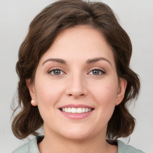 Joyful white young-adult female with medium  brown hair and green eyes