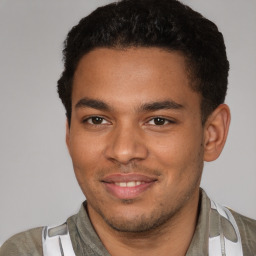 Joyful black young-adult male with short  brown hair and brown eyes