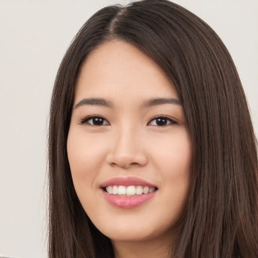 Joyful asian young-adult female with long  brown hair and brown eyes