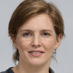 Joyful white young-adult female with medium  brown hair and grey eyes