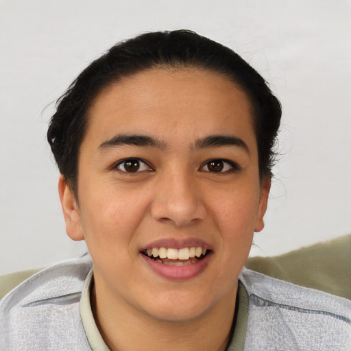 Joyful latino young-adult female with short  black hair and brown eyes