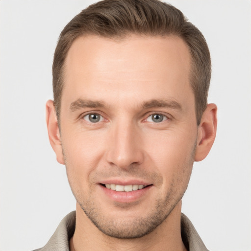 Joyful white young-adult male with short  brown hair and grey eyes