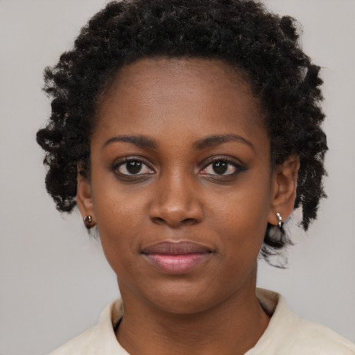 Joyful black young-adult female with short  black hair and brown eyes