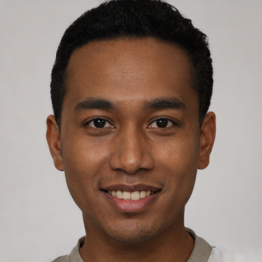 Joyful black young-adult male with short  black hair and brown eyes