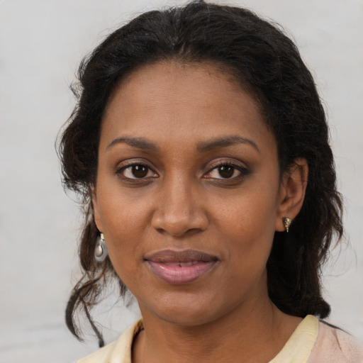 Joyful black young-adult female with medium  brown hair and brown eyes