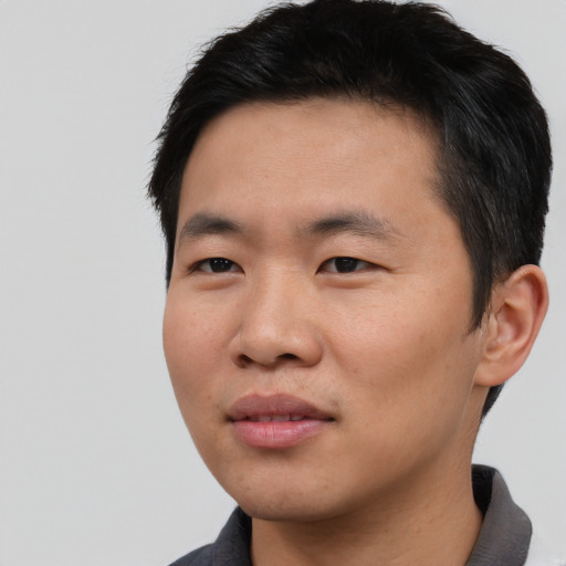Joyful asian young-adult male with short  black hair and brown eyes